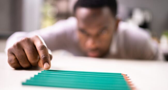 man tidying pencils showing signs of OCD man tidying pencils showing signs of OCD