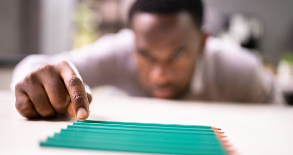man tidying pencils showing signs of OCD